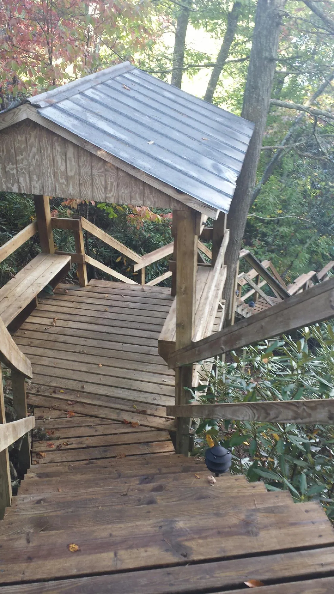Metal roofed shelter over wooden steps on a wooded walkway — Skylight Repair & Installation work by our crew in Epping